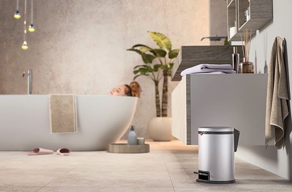 Woman in a bath tub next to a Hailo waste bin