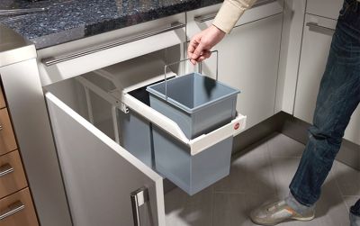 A person pulls an inner bucket out of a built-in waste bin