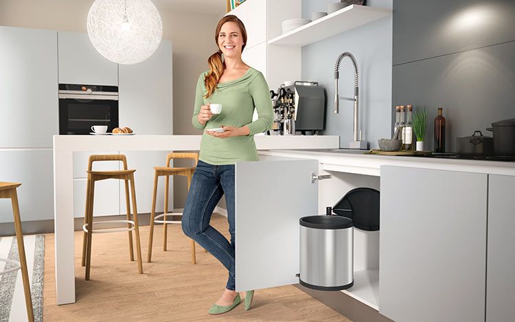 A woman sits in the kitchen at her laptop